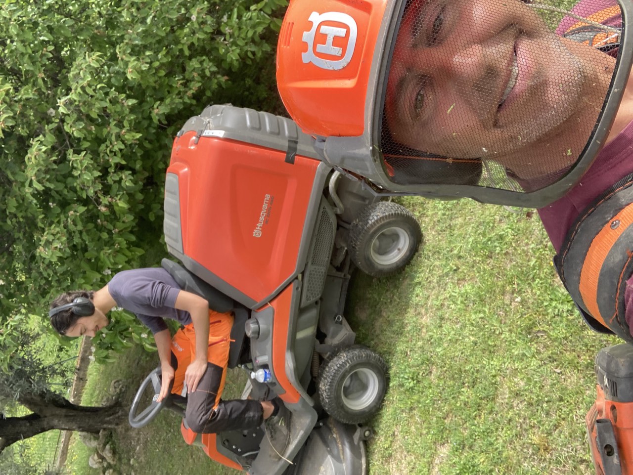Équipe au jardin avec une tondeuse autoportée sur la pelouse